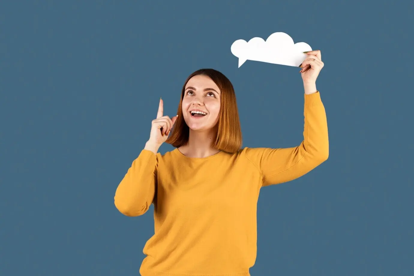 Eine junge Frau hält eine Gedankenblase in der Hand.